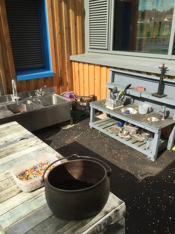 Mud kitchen area with pots, pans and a sink outdoors, Ysgol Feithrin Y Trallwng, Welshpool