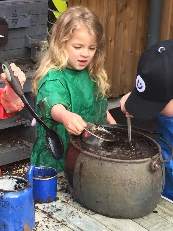 Child using the outdoor woodwork bench, Ysgol Feithrin Y Trallwng, Welshpool